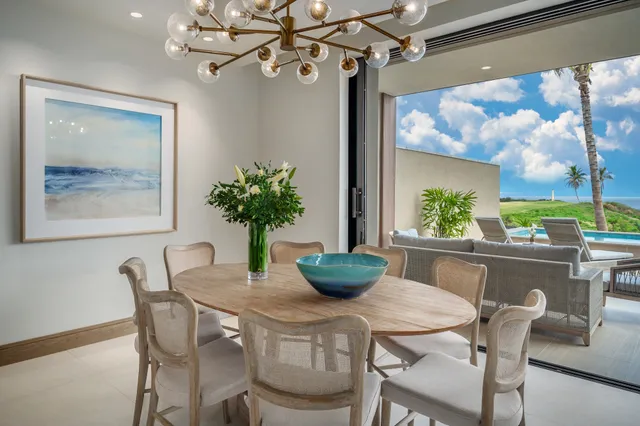 a dining room with furniture a large window and a potted plant