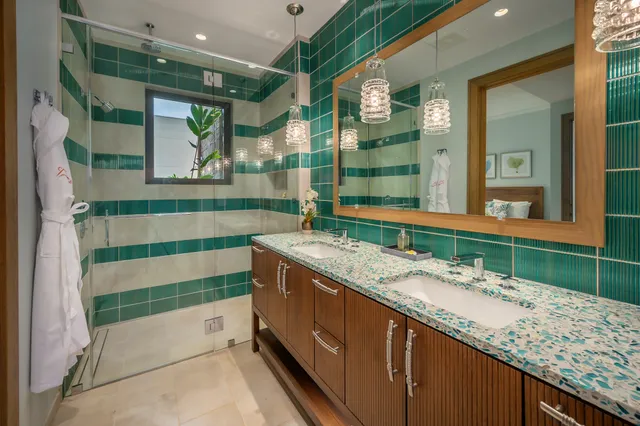 a bathroom with a granite countertop sink and a large mirror