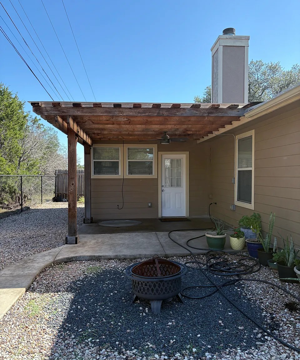 430 Summit Ridge Drive North Point Venture, TX 78645 - Photo 19 of 26 A charming wooden pergola offers shade over the patio, providing an ideal spot for outdoor enjoyment.