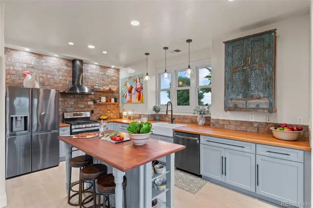 a kitchen with stainless steel appliances kitchen island granite countertop a sink and cabinets