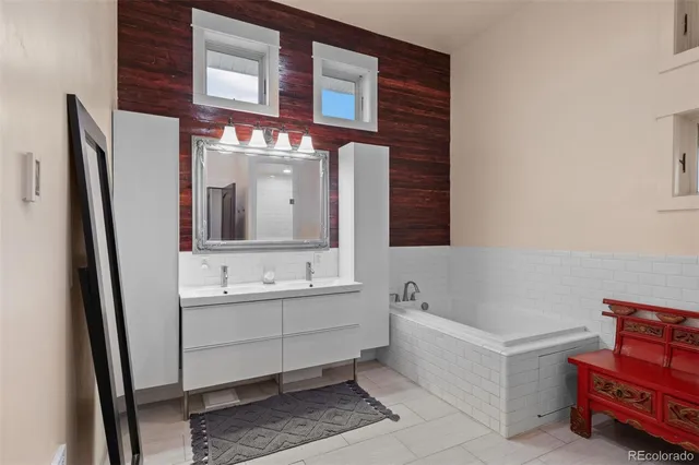 a bathroom with a double vanity sink mirror and bathtub