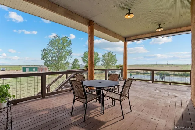 a view of a balcony with furniture and wooden floor