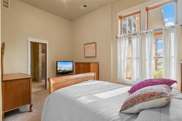 a bedroom with a bed and a flat tv screen