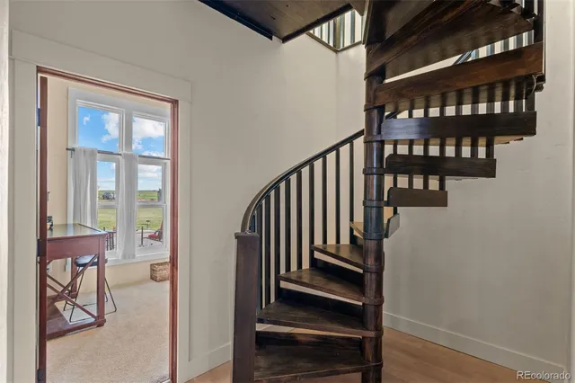 a view of staircase with lots of frames on wall and a window