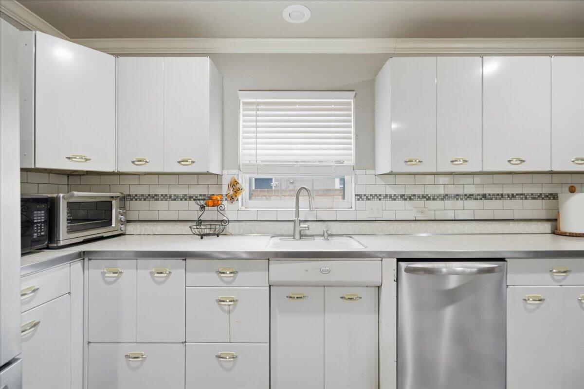 3607 27th Street Lubbock, TX 79410 - Photo 16 of 30 a kitchen with granite countertop white cabinets and a sink