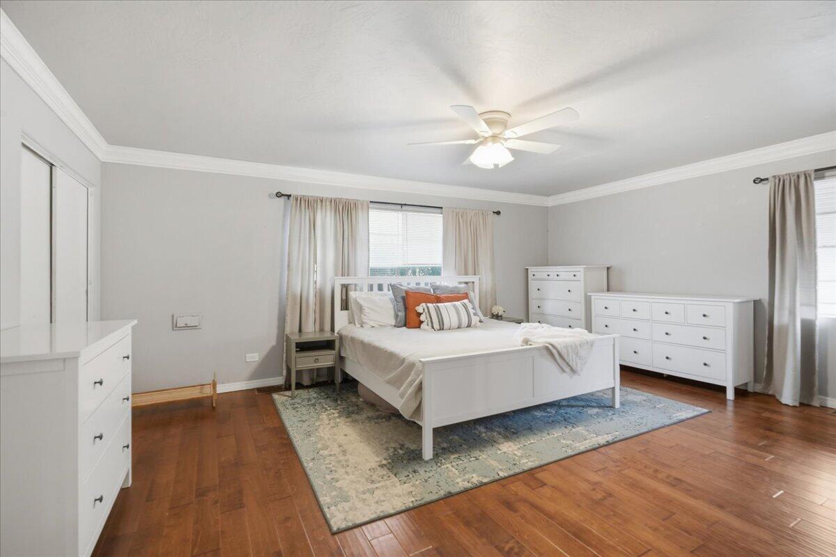 3607 27th Street Lubbock, TX 79410 - Photo 17 of 30 a white bedroom with a bed and a chandelier