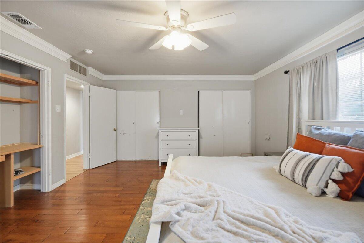 3607 27th Street Lubbock, TX 79410 - Photo 18 of 30 a spacious bedroom with a bed and a chandelier