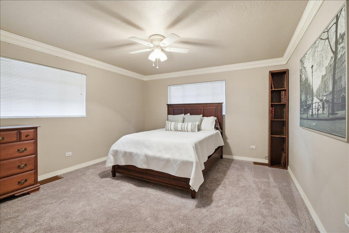 3607 27th Street Lubbock, TX 79410 - Photo 21 of 30 a bed sitting in a room next to a lamp and a chandelier