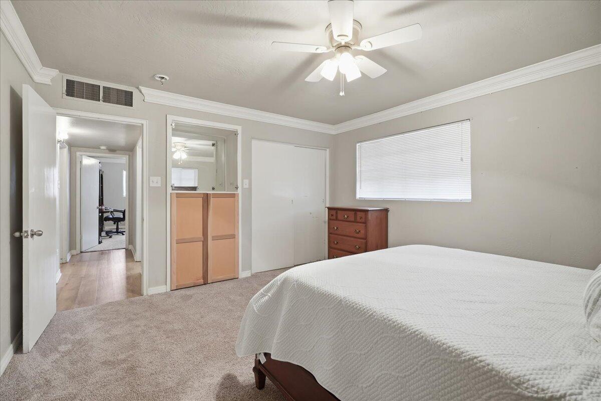 3607 27th Street Lubbock, TX 79410 - Photo 22 of 30 a bedroom with a large bed and a chandelier