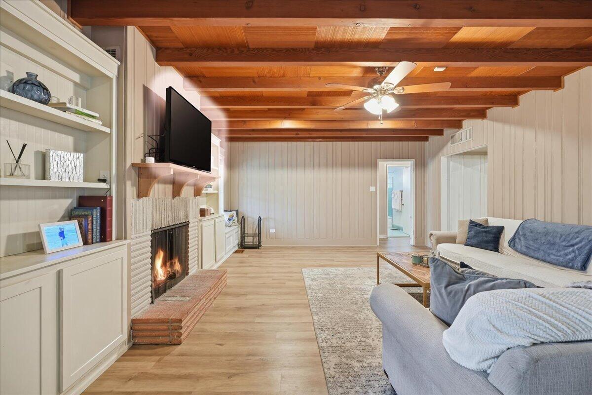 3607 27th Street Lubbock, TX 79410 - Photo 6 of 30 a living room with furniture a flat screen tv and a fireplace