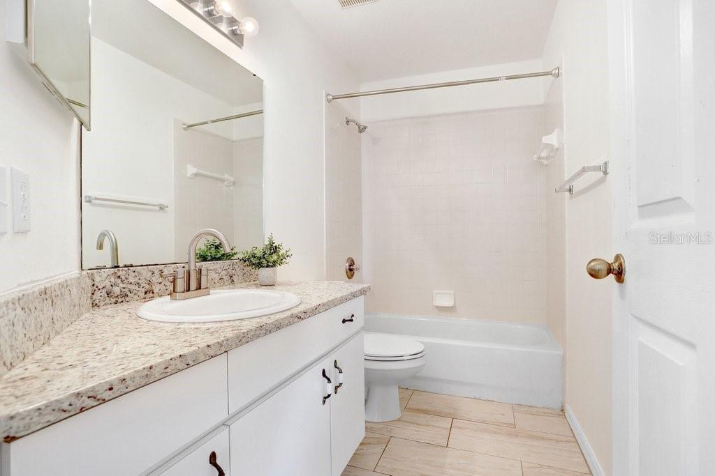 517 Royal Ridge Street Valrico, FL 33594 - Photo 18 of 30 a bathroom with a granite countertop sink a toilet and shower