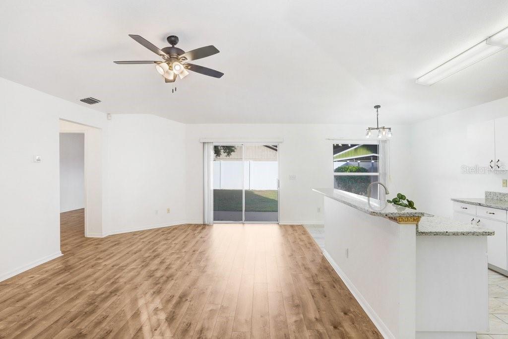 517 Royal Ridge Street Valrico, FL 33594 - Photo 6 of 30 a view of a livingroom with wooden floor and a ceiling fan