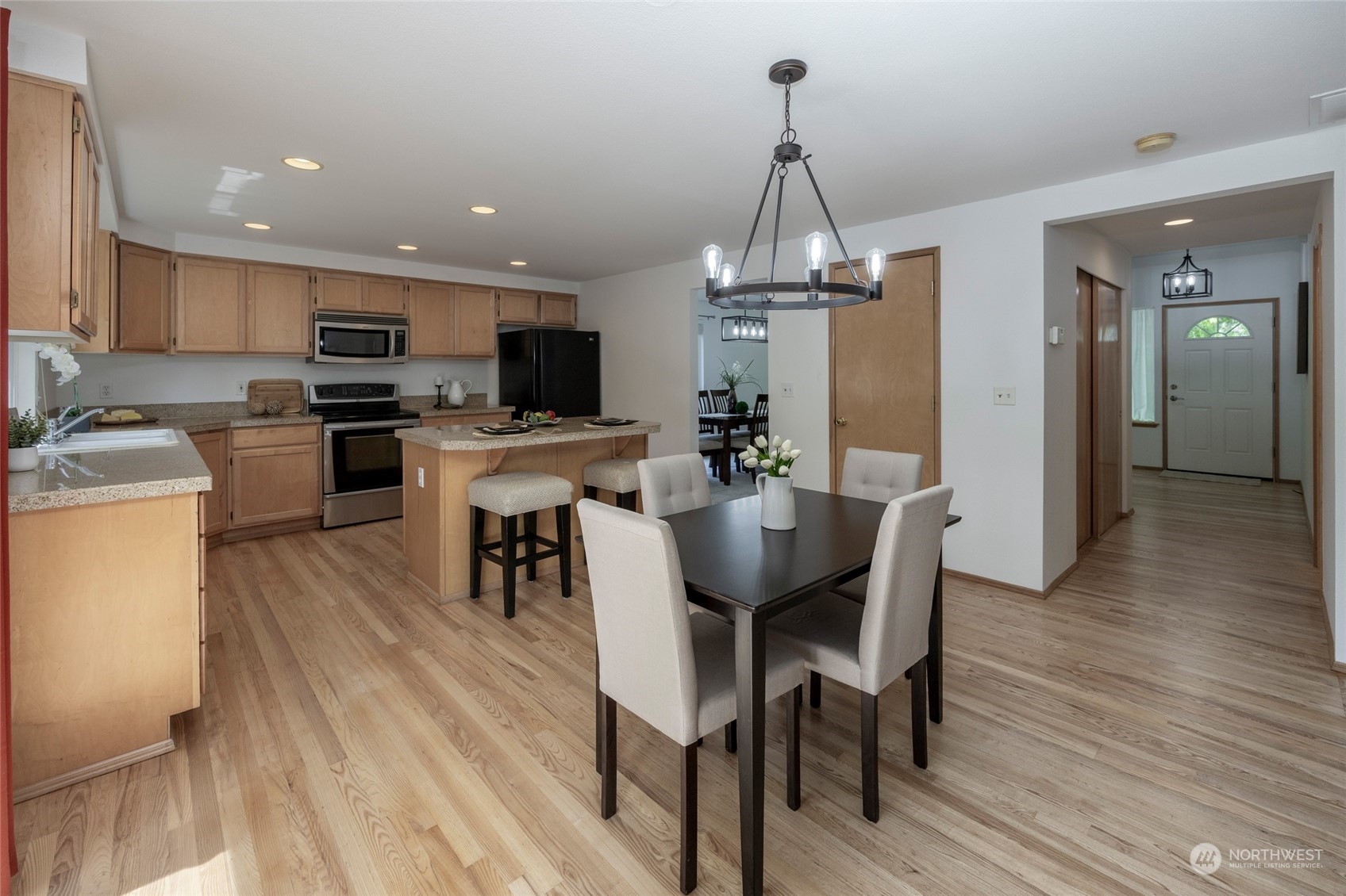 14439 Southeast 185th Place Renton, WA 98058 - Photo 12 of 36 a view of a dining room and livingroom with furniture wooden floor a chandelier