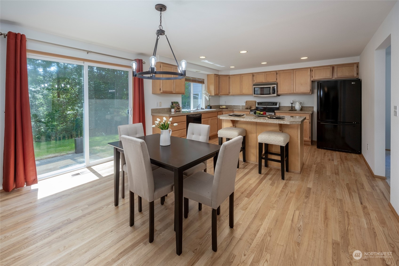 14439 Southeast 185th Place Renton, WA 98058 - Photo 15 of 36 a dining room with stainless steel appliances granite countertop a dining table chairs stove a refrigerator and chandelier