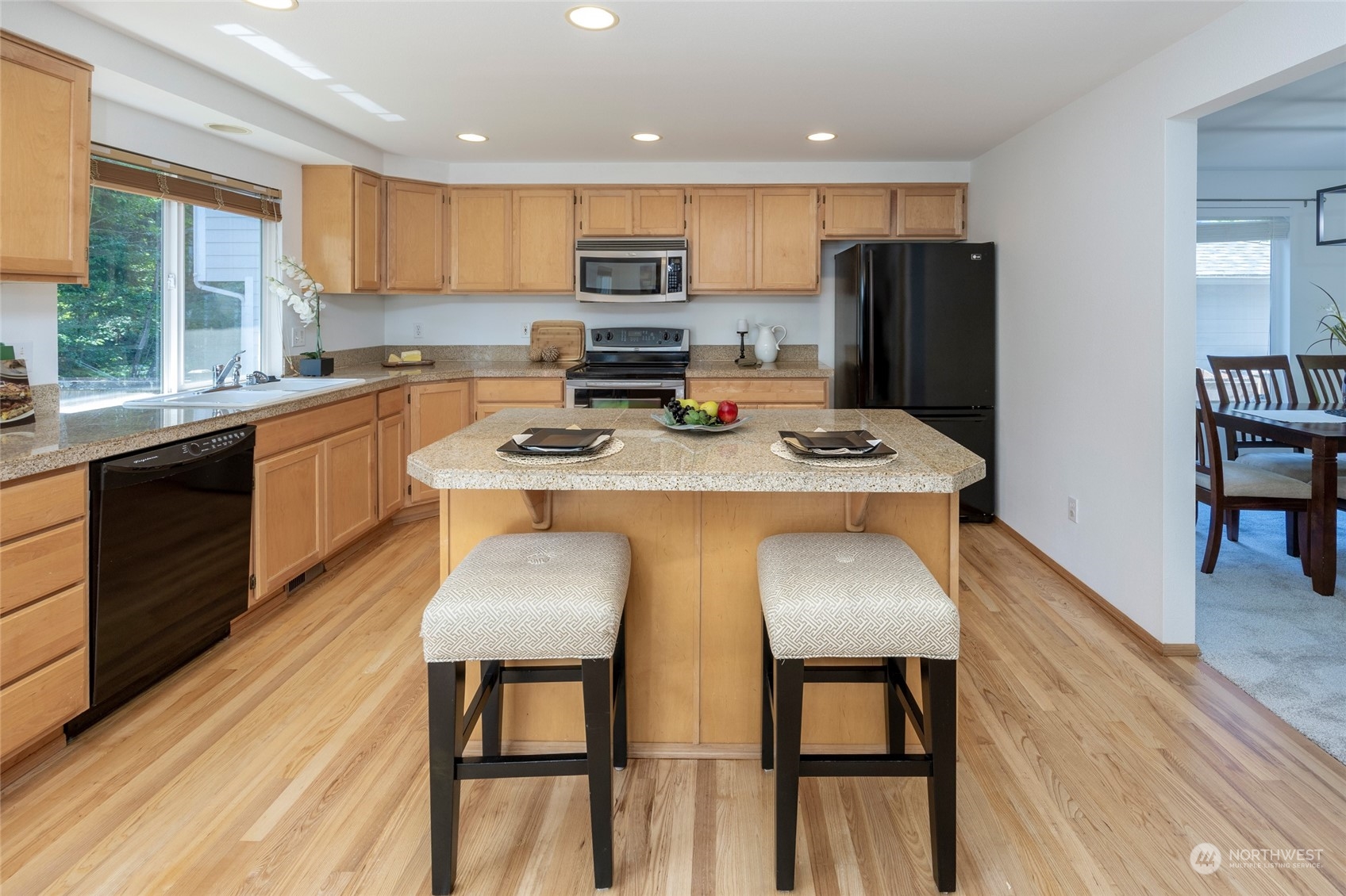 14439 Southeast 185th Place Renton, WA 98058 - Photo 8 of 36 a kitchen with stainless steel appliances granite countertop a refrigerator a stove top oven a sink dishwasher and white cabinets with wooden floor