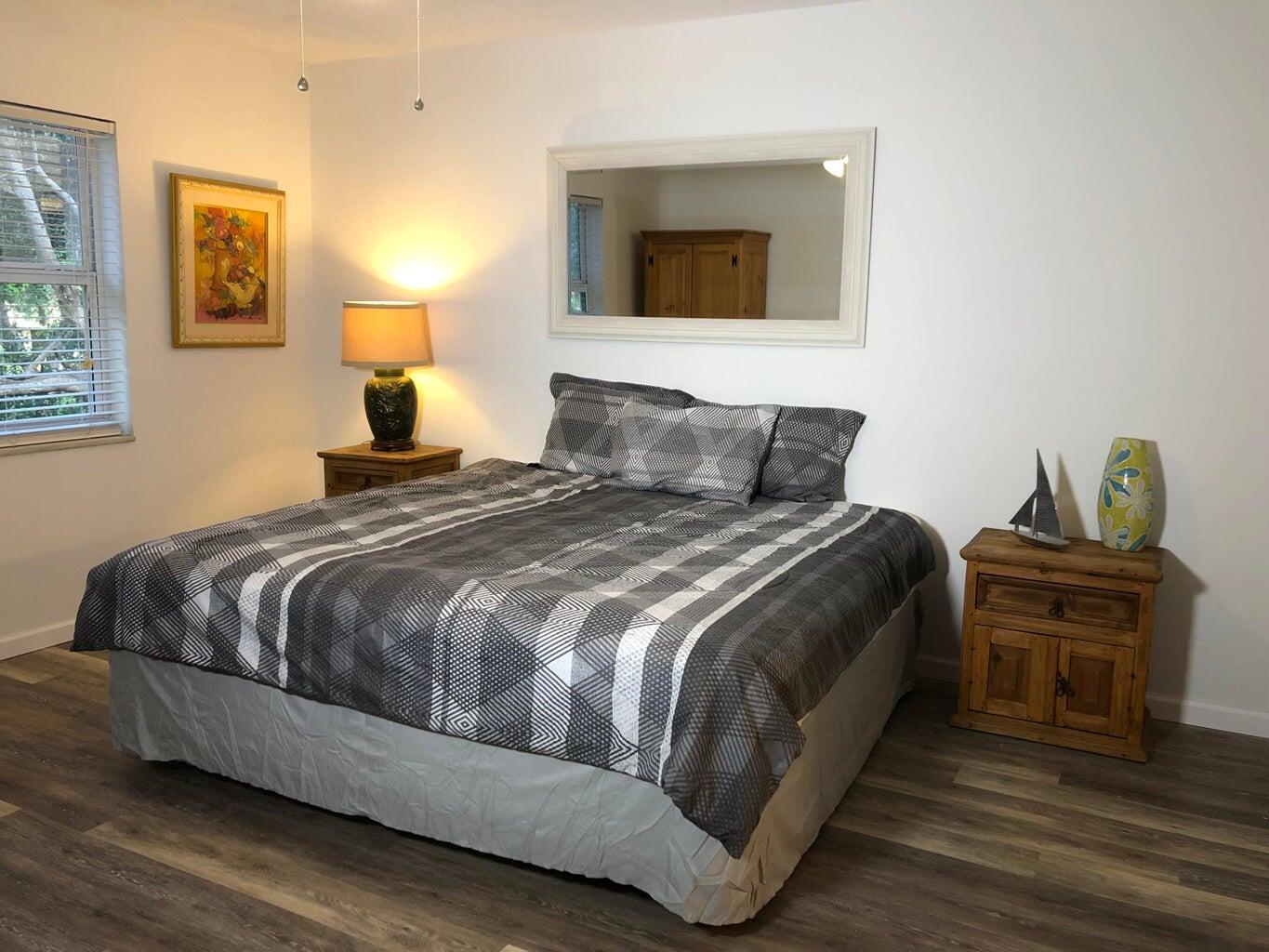 9826 Marina Boulevard, Unit 1023 Boca Raton, FL 33428 - Photo 12 of 31 a bedroom with a bed and wooden floor