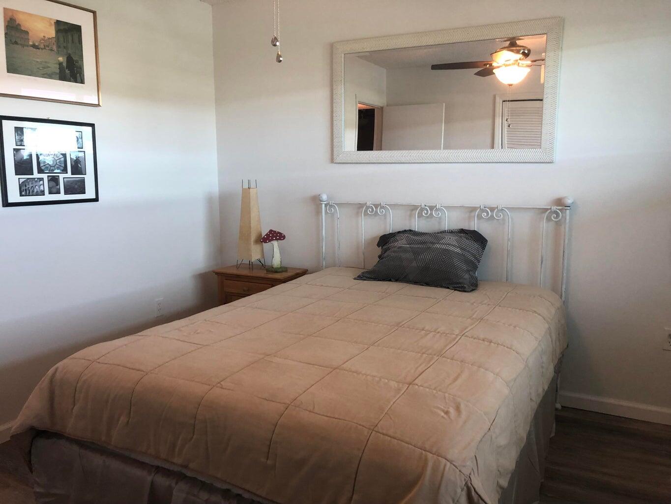 9826 Marina Boulevard, Unit 1023 Boca Raton, FL 33428 - Photo 18 of 31 a bedroom with a bed and a painting on the wall