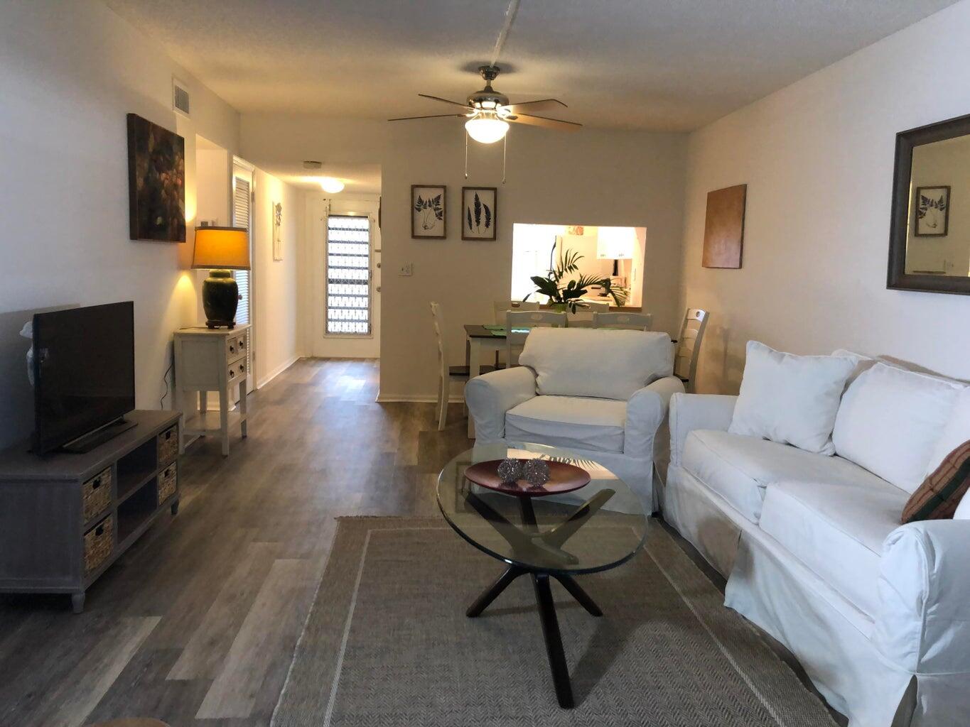 9826 Marina Boulevard, Unit 1023 Boca Raton, FL 33428 - Photo 3 of 31 a living room with furniture a fireplace and a flat screen tv