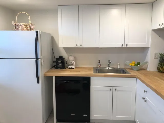 a kitchen with a sink a refrigerator and cabinets