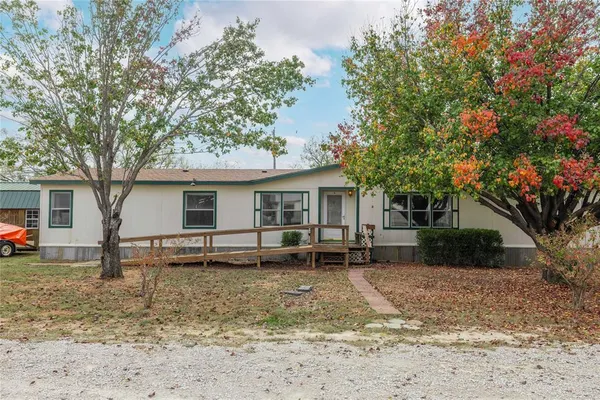 a view of a house with a yard and large tree