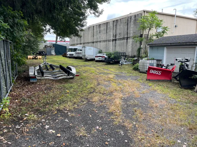 a view of a backyard with table and chairs potted plants and a large tree
