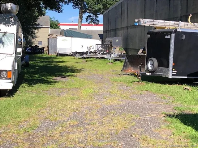a backyard of a house with barbeque oven and outdoor seating