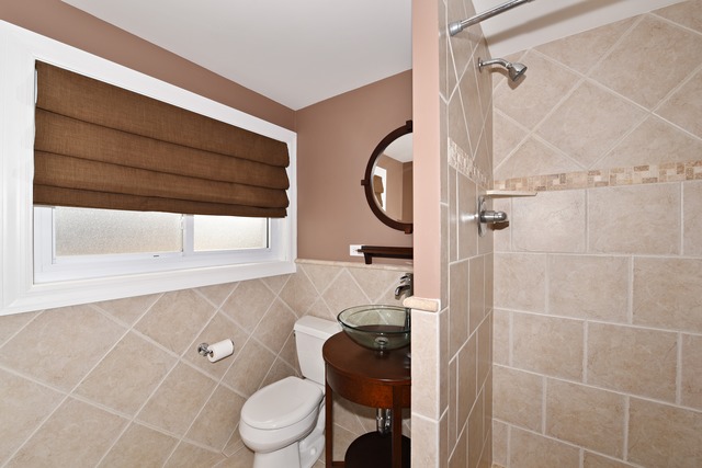 7706 Sawyer Road Darien, IL 60561 - Photo 9 of 10 a bathroom with a toilet and a shower