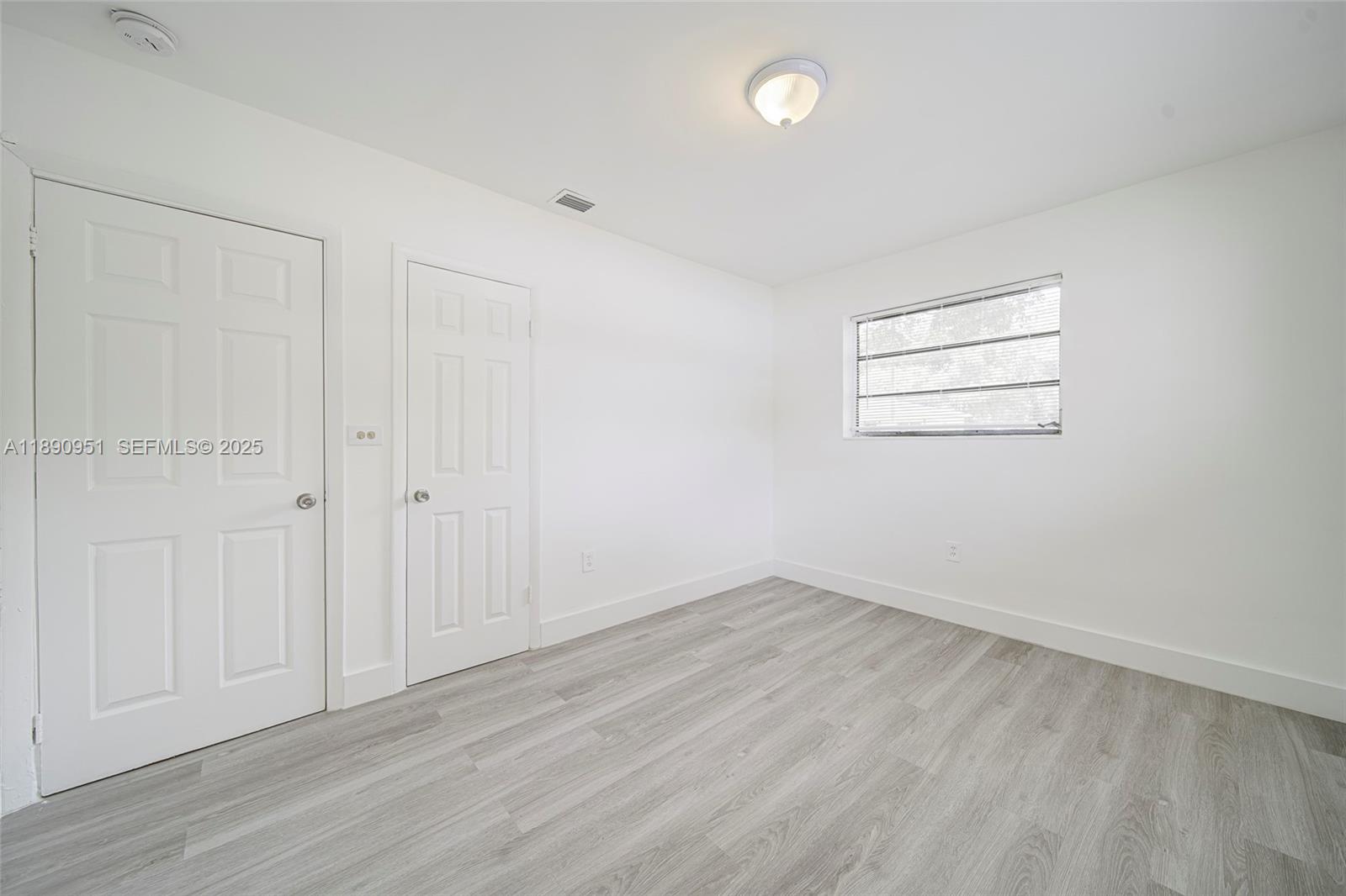 6735 Northwest 2nd Court, Unit 1 Miami, FL 33150 - Photo 7 of 27 an empty room with wooden floor and windows
