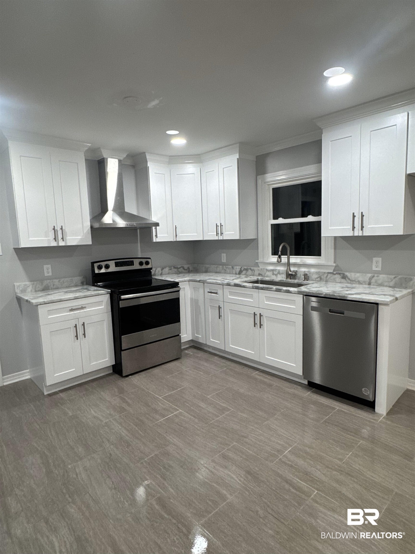 3901 Prima Vera Lane Mobile, AL 36605 - Photo 12 of 15 Kitchen featuring sink, appliances with stainless steel finishes, light stone counters, white cabinets, and wall chimney exhaust hood