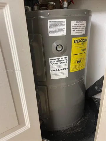 a view of a room with a refrigerator and wooden floor