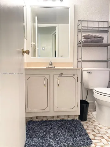 a bathroom with a sink a toilet and a mirror