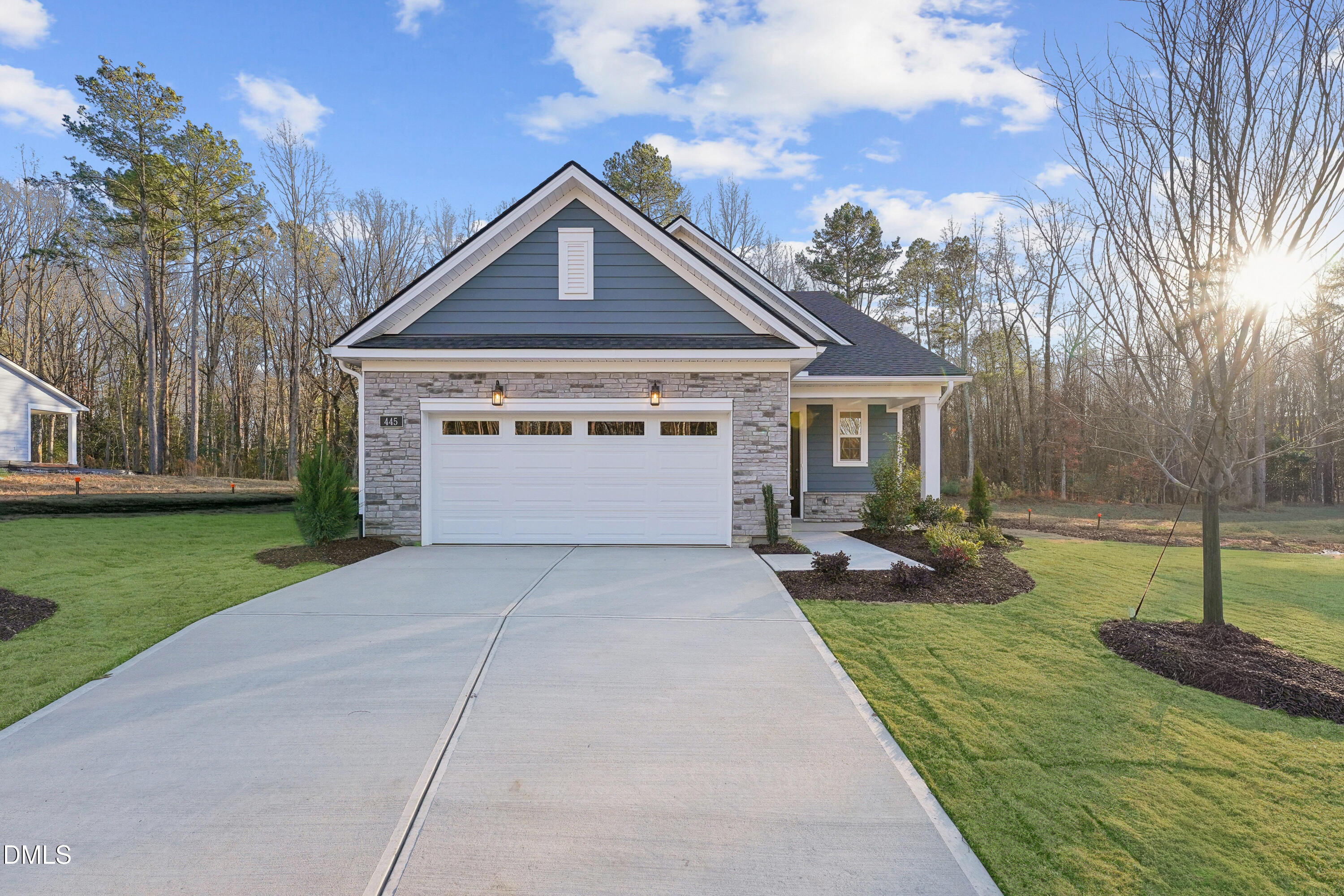 a front view of a house with a yard and trees