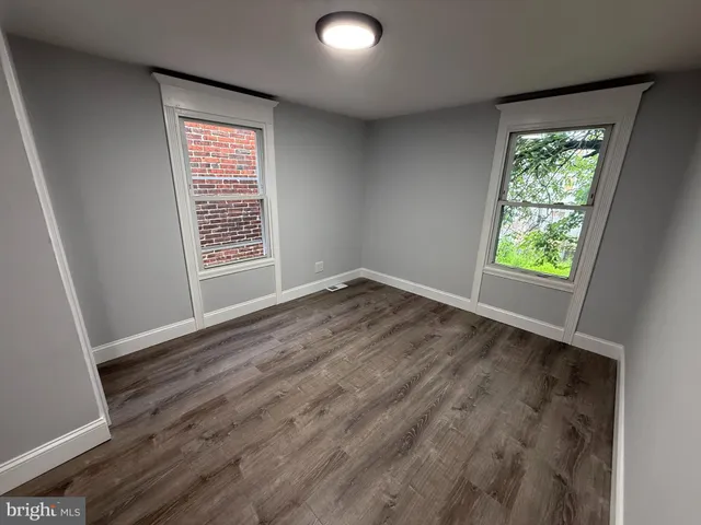 an empty room with wooden floor and door