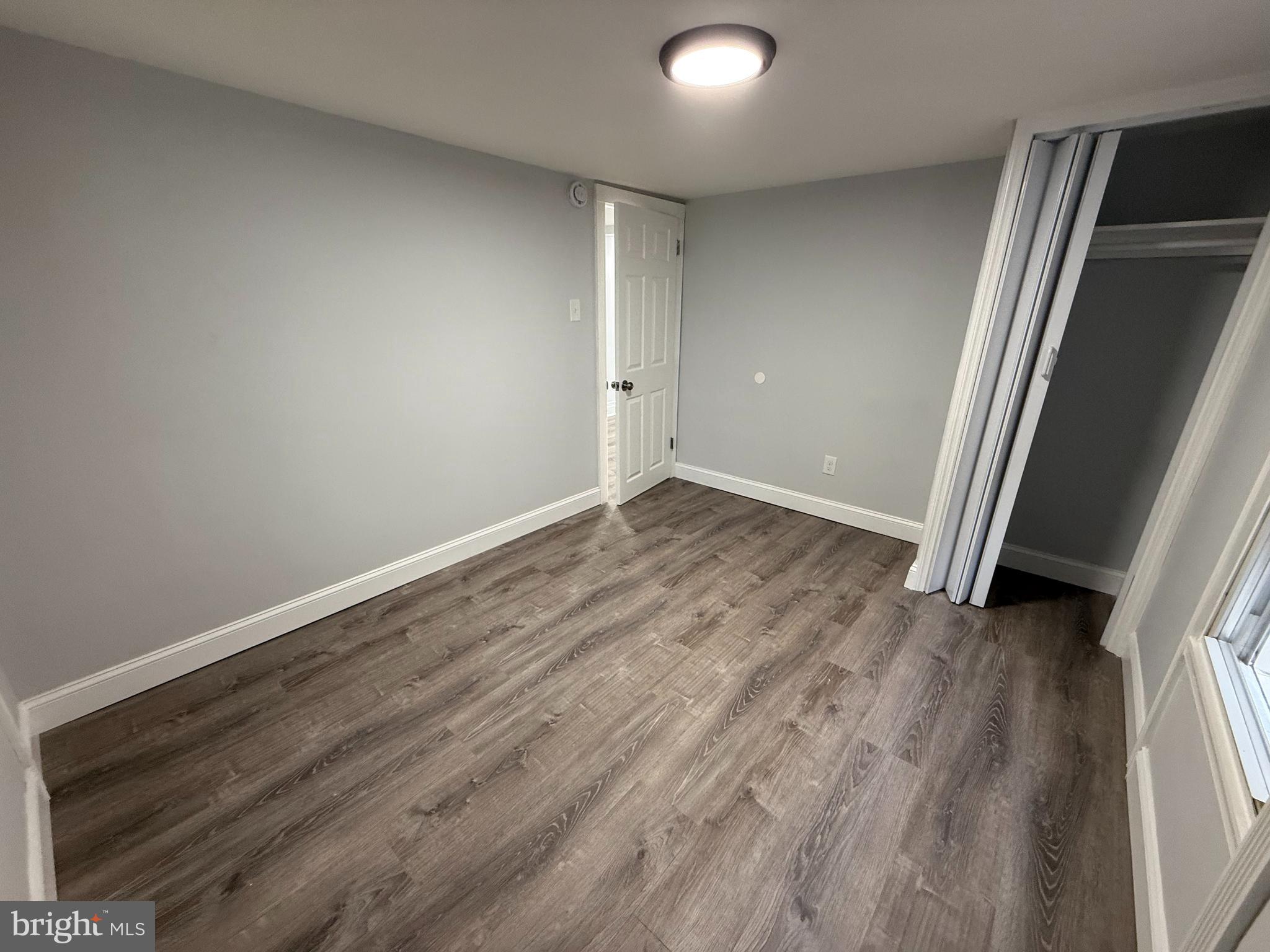 340 Middlesex Street Gloucester City, NJ 08030 - Photo 23 of 35 an empty room with wooden floor and door