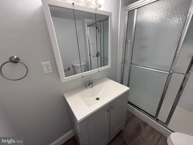 a bathroom with a glass shower door and mirror