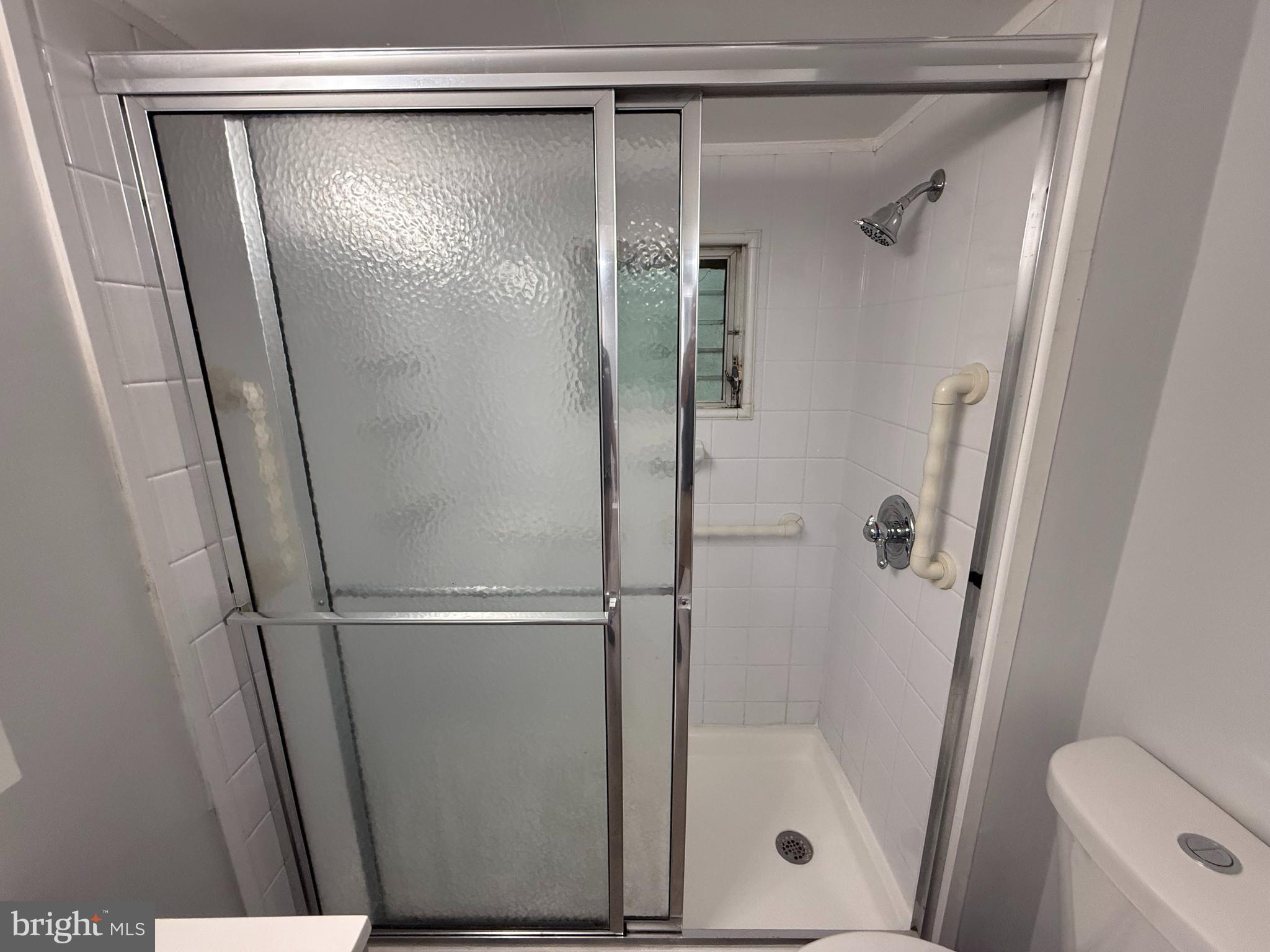 340 Middlesex Street Gloucester City, NJ 08030 - Photo 26 of 35 a bathroom with a glass shower door and mirror