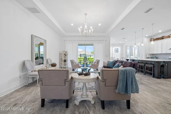 a kitchen with kitchen island granite countertop a stove a sink a dining table and chairs