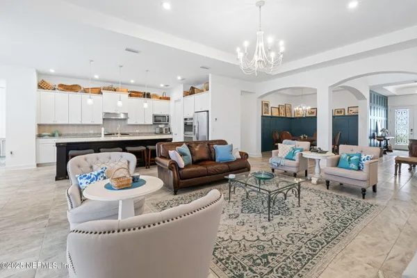 a large kitchen with a large counter top a sink stainless steel appliances and cabinets