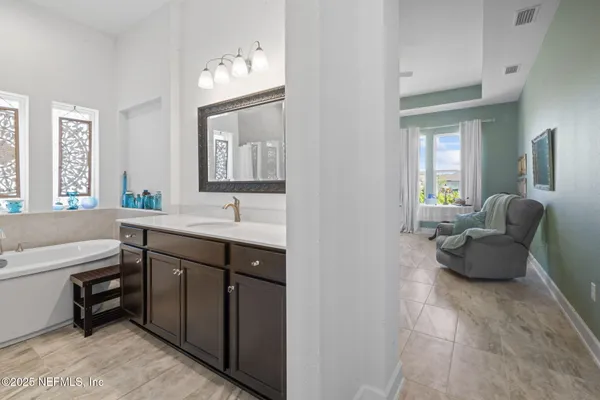 a bedroom with a bed and a lamp on dresser