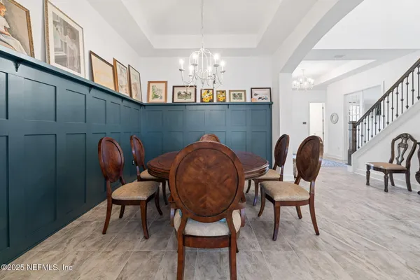 a living room with furniture a chandelier and a fireplace