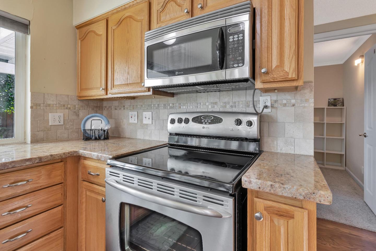360 Henderson Drive San Jose, CA 95123 - Photo 12 of 37 a kitchen with granite countertop a stove top oven microwave and cabinets