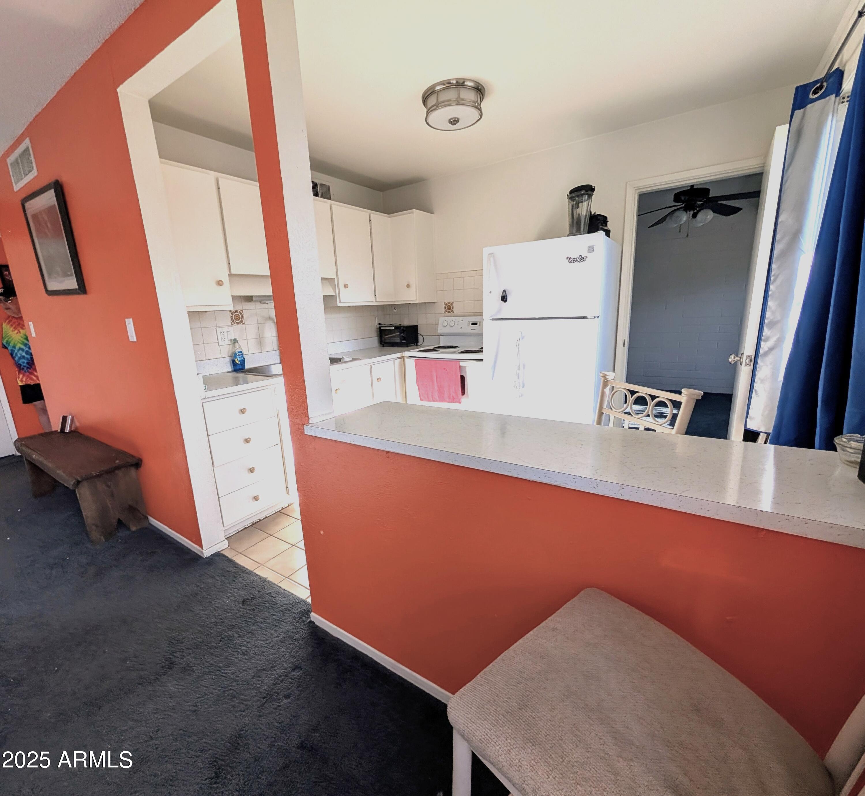 2610 West Berridge Lane, Unit 121 Phoenix, AZ 85017 - Photo 14 of 18 a room with furniture a white wall and a refrigerator