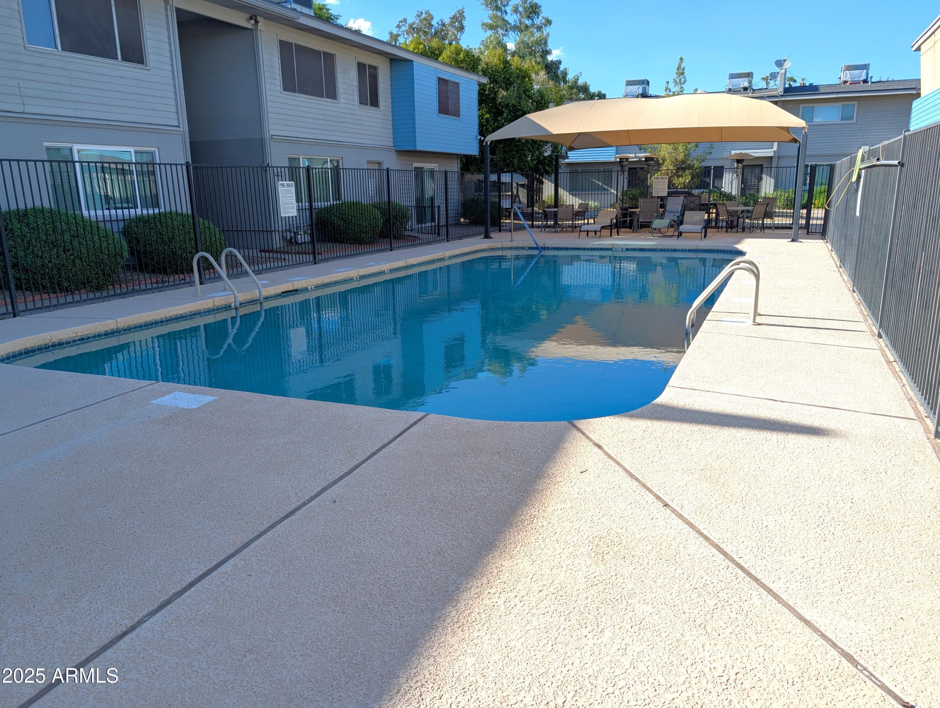 2610 West Berridge Lane, Unit 121 Phoenix, AZ 85017 - Photo 17 of 18 a view of a patio with a table and chairs under an umbrella