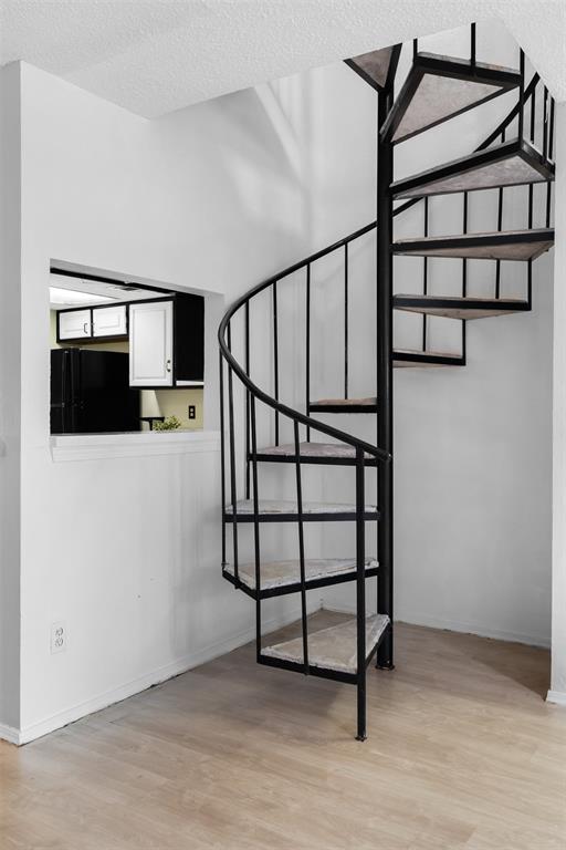 5590 Spring Valley Road, Unit H 203 Dallas, TX 75254 - Photo 7 of 27 Black metal spiral staircase with carpeted treads