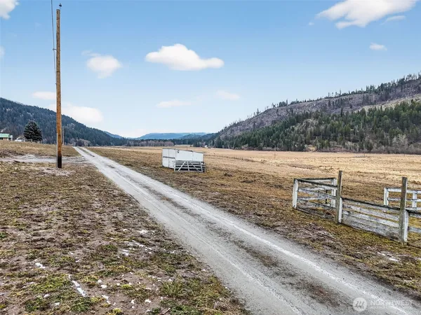 a view of empty field with trees in background