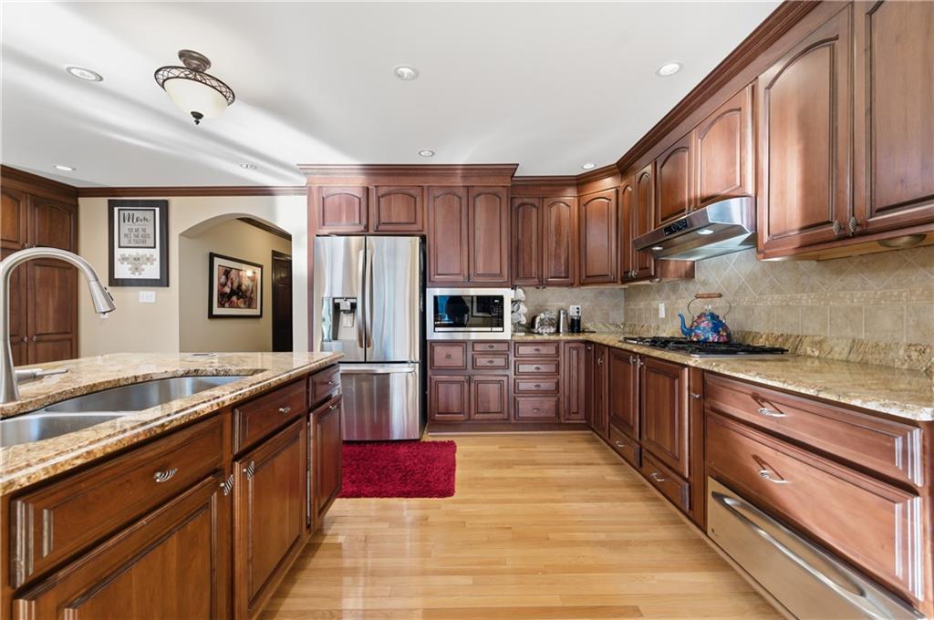 4220 Greentree Lane Southwest Atlanta, GA 30349 - Photo 13 of 42 a large kitchen with stainless steel appliances granite countertop a stove refrigerator sink and cabinets