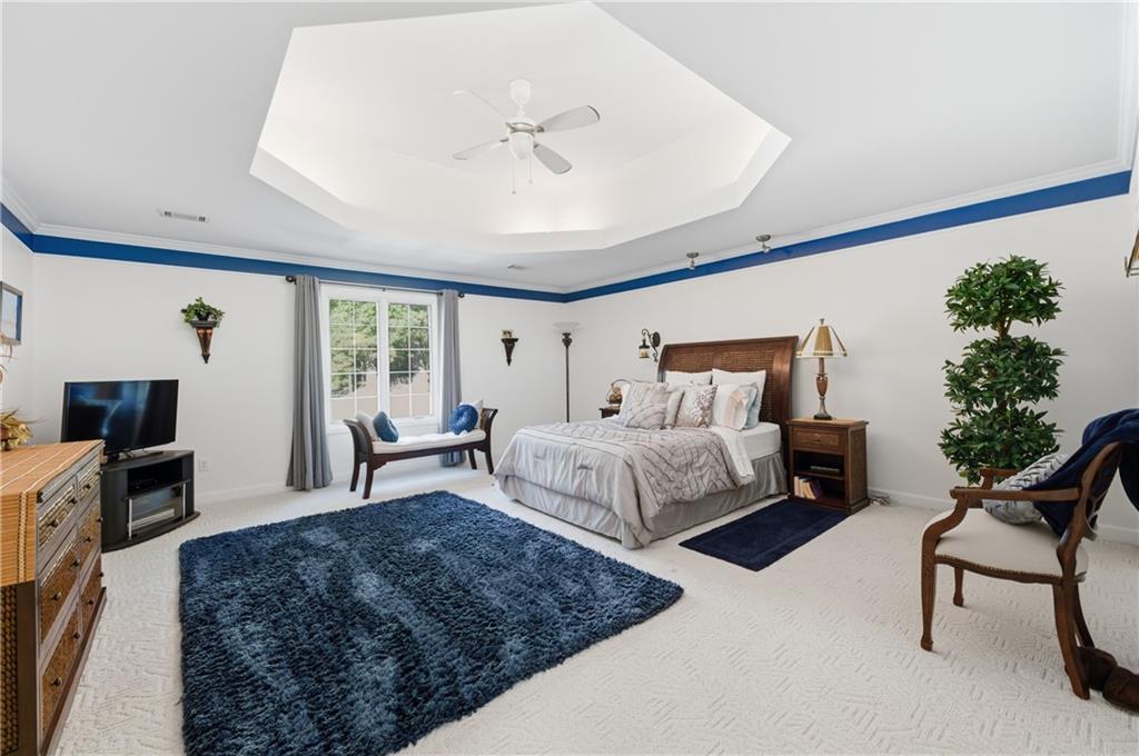 4220 Greentree Lane Southwest Atlanta, GA 30349 - Photo 28 of 42 a bedroom with a large bed and a chandelier