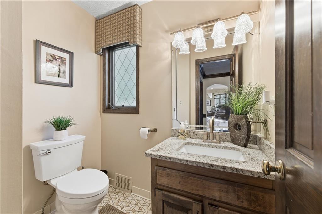 4220 Greentree Lane Southwest Atlanta, GA 30349 - Photo 8 of 42 a bathroom with a granite countertop sink a toilet and mirror