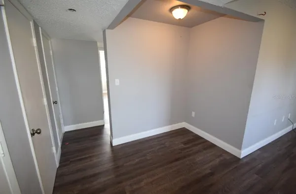 an empty room with wooden floor and closet