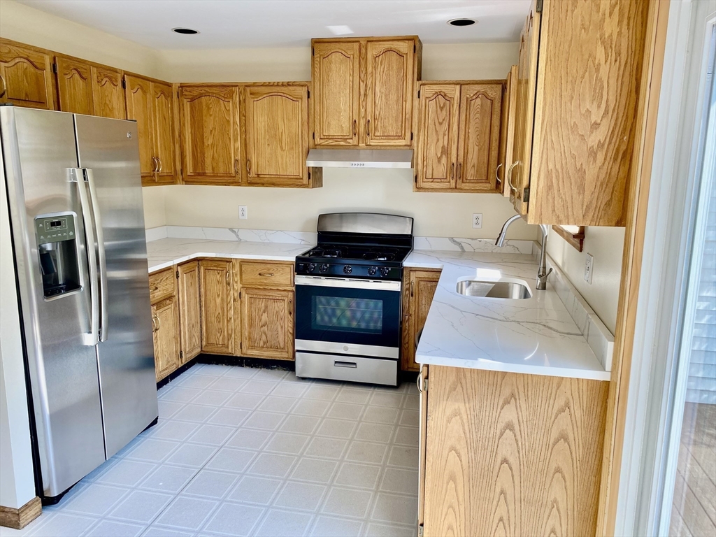 a kitchen with stainless steel appliances granite countertop a refrigerator and a stove
